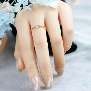 Detailed shot of gold plated marquise opal ring with purple gems on model hand
