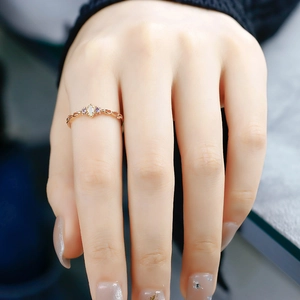 Detailed view of vintage gold ring with marquise opal and side stones on finger