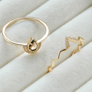 Vista macro de anillos bañados en oro 14k con cuarzo ahumado gota y banda de circonitas