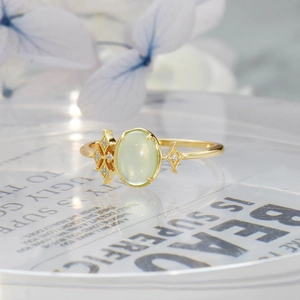 Macro detail of S925 silver 14K gold ring with oval prehnite and starburst accents