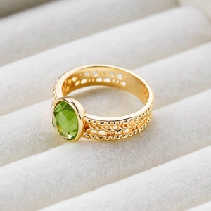 Makroansicht des Vintage Goldrings mit grünem Edelstein und Blatt-Hohlraum-Muster