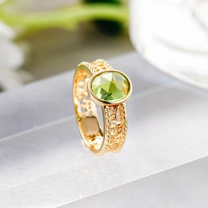 Makroaufnahme: S925 Silberring in Gold mit facettiertem grünem Oliven-Edelstein