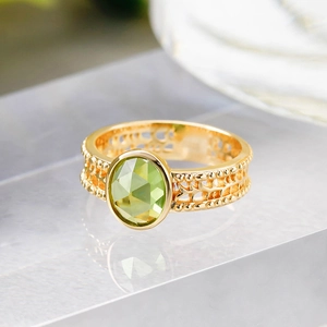 Makroaufnahme von Vintage S925 Silberring mit grünem Edelstein und hohlen Goldmustern