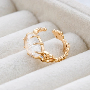 Détail de la bague ajustable dorée avec fleur en cristal blanc et zircons brillants