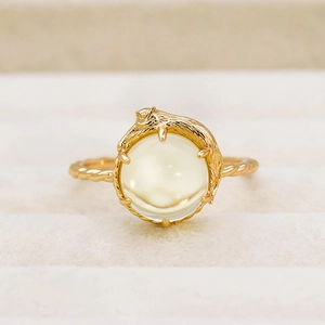 Anello gatto con gemma di citrino giallo rotondo e fascia dorata intrecciata da donna