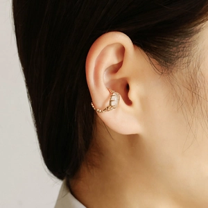 Détail du bijou d'oreille en argent plaqué or 14K avec cristal blanc et texture de chaîne