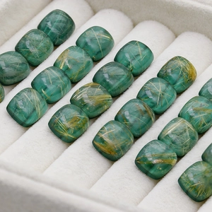 Macro view of cushion-cut green rutilated quartz gems with golden hair inclusions