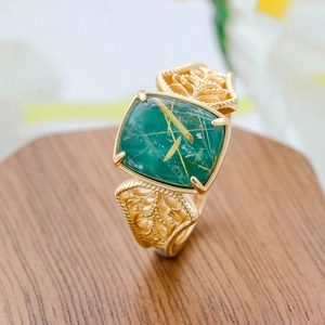 Macro detail of vintage S925 silver ring with square green gemstone and floral patterns