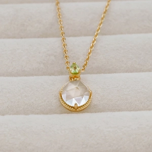 Makroaufnahme der 14k vergoldeten S925-Silberkette mit grünem Peridot und Amethyst-Anhänger