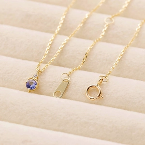 Détail macro d'un collier en argent 925 plaqué or avec un pendentif tanzanite ronde