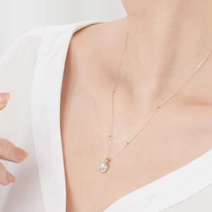 Detail einer minimalistischen 14k vergoldeten Silberkette mit Edelstein auf einem Model