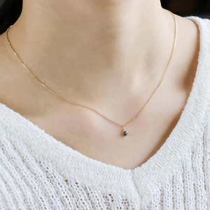 Gros plan du collier minimaliste en argent doré avec pendentif tanzanite bleue ronde