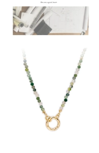 Detail of faceted moss agate beads necklace with a golden hammered texture ring clasp