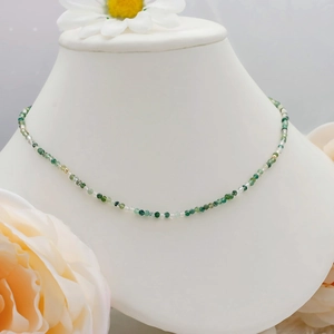 Detail of S925 silver plated 14K gold necklace with green moss agate beads on a model
