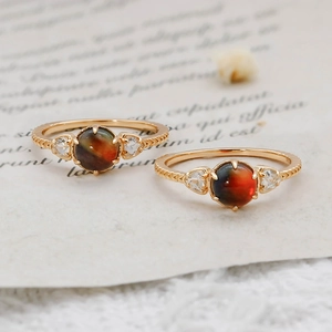 Gros plan de deux bagues vintage en argent S925 avec cristaux rouges et texture tressée