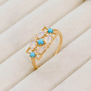 Vue macro d'une bague rétro en argent S925 avec turquoise et opale sur plateau beige