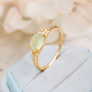 Macro shot of S925 silver 14K gold plated ring with oval prehnite stone and side diamonds