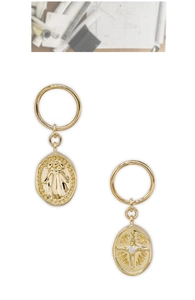 Detail of vintage 14K gold plated earrings with embossed figure and starburst zircon
