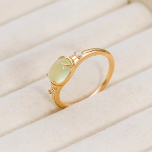 Macro detail of oval prehnite ring in 14K gold plated silver on white velvet box