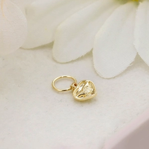 Macro shot of 14K gold-plated double-sided heart pendant with embossed texture