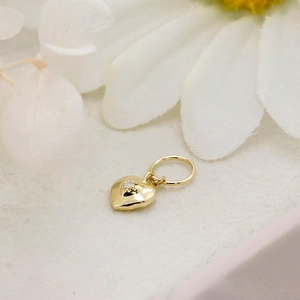 Macro shot of 14K gold plated heart pendant with a center-set sparkling zircon