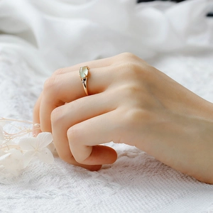 Close-up of a vintage S925 silver 14K gold ring with an oval prehnite stone and side diamonds