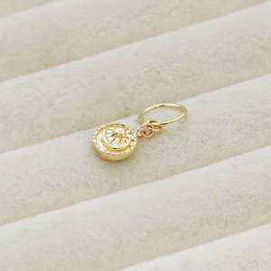 Macro shot of the 10K gold purity hallmark on the edge of the celestial star and moon pendant