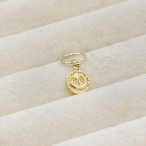 Macro detail of a 14K gold plated silver celestial pendant with crescent moon and stars
