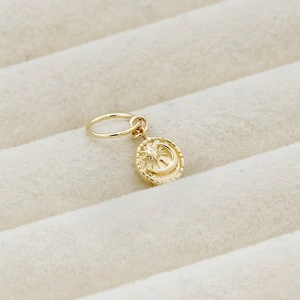 Macro shot of gold-plated 14K silver pendant featuring celestial moon and star relief