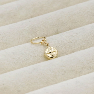 Detail shot of a vintage 14K gold plated silver bird pendant on velvet lining