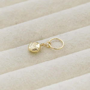 Macro shot of a 14K gold plated double-sided 3D geometric pendant with embossed textures