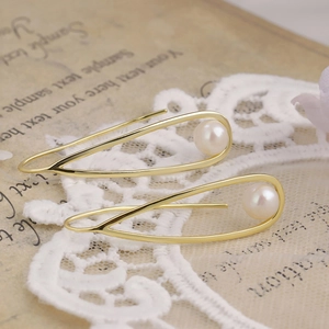 Detail view of teardrop S925 silver earrings with freshwater pearl on lace background