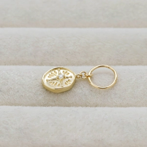 Macro detail of oval 14K gold-plated S925 silver pendant with starburst crystal