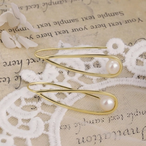 Macro shot of 14K gold plated teardrop wire earrings with elegant natural pearls