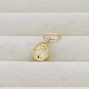 Macro shot of 14K gold-plated oval pendant featuring vintage embossed portrait detail