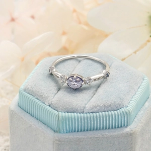 Minimalist S925 silver ring with oval lilac gemstone on a light blue velvet jewelry box
