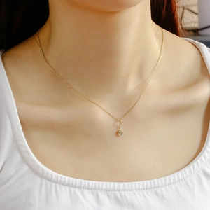 Close-up of a 14K gold plated vintage sunburst relief pendant on a delicate chain