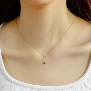 Detail of minimalist 14K gold-plated S925 silver necklace with textured bean pendant