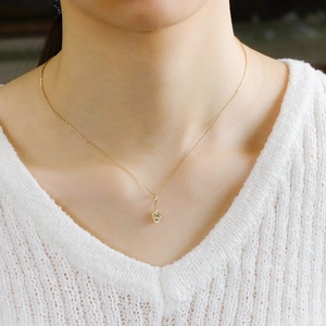 Close-up of a 14K gold plated S925 silver oval relief pendant necklace on a model
