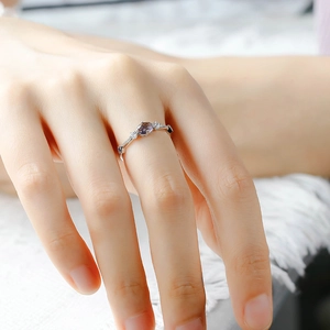 Macro shot of S925 silver ring featuring an oval purple gemstone and side diamond accents