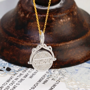 Dettaglio macro del ciondolo bicolore reversibile con incisione vintage e stile zodiacale
