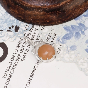 Dettaglio macro di un ciondolo reversibile in argento S925 con pietra di luna arancione