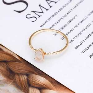 Detail eines 14K vergoldeten Tropfen-Rosenquarz-Rings auf elegantem Magazin-Hintergrund