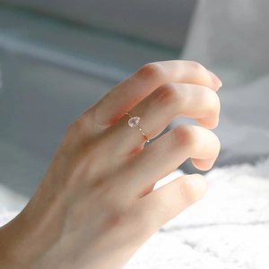 Detailaufnahme des tropfenförmigen Rosenquarz-Rings mit vergoldetem gedrehtem Band