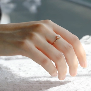 Detailaufnahme eines tropfenförmigen Rosenquarz-Rings mit 14K Vergoldung auf Spitze