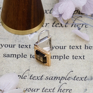 Macro shot of S925 sterling silver vintage lock pendant with smoky brown quartz gemstone