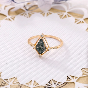 Vue macro d'une bague en agate mousse cerf-volant avec petits diamants sur or poli