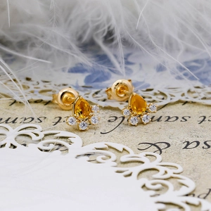 Dettaglio orecchini con citrino giallo a goccia e alone di diamanti su placcatura oro