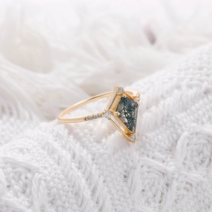 Détail macro d'une bague en agate mousse taille cerf-volant plaquée or 14K sur tricot