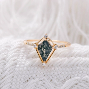 Vue macro d'une bague en agate mousse en forme de cerf-volant en or rose avec diamants
